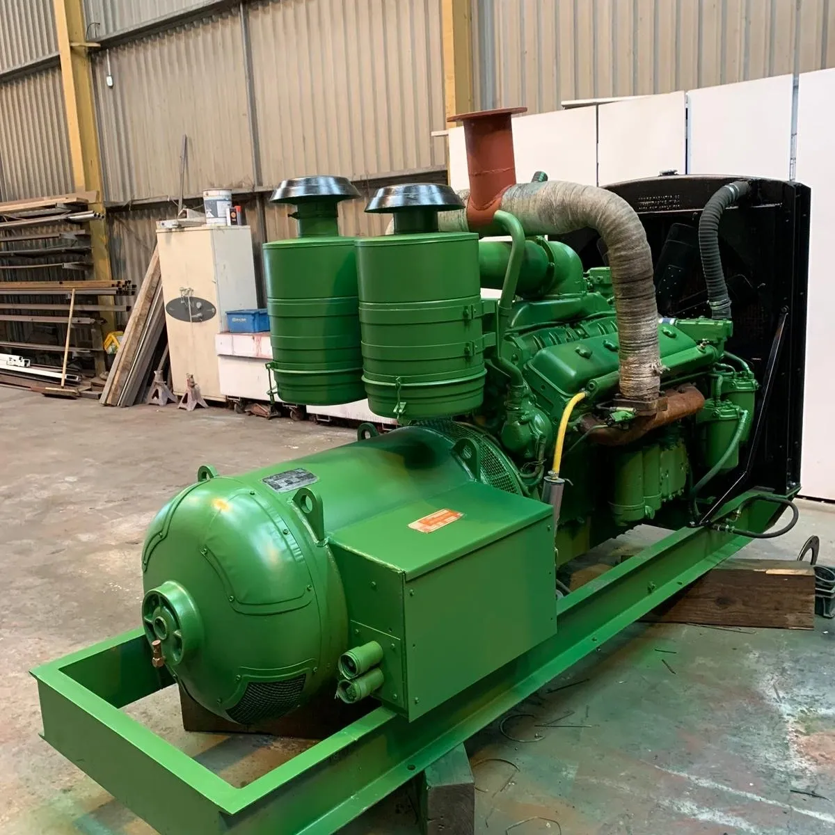 Large green engine equipment indoors